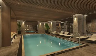 a large swimming pool in a building with chairs at Arts Hotel Taksim in Istanbul