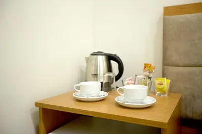 a table with two cups and a coffee pot on it at Kartal Palace Taksim Square FAMILY HOTEL in Istanbul