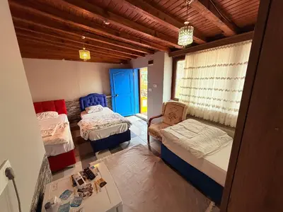 a room with two beds and a chair in it at ÖZ Butik Otel Antik Kent Myrleia in Mudanya