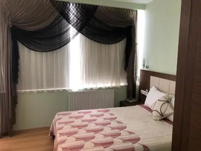 a bedroom with a bed and a window with curtains at Hivas Hotel in Istanbul