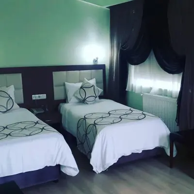 a hotel room with two beds and a window at Hivas Hotel in Istanbul