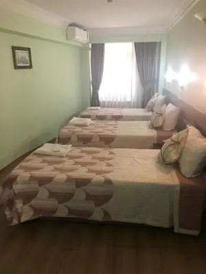 two beds in a hotel room with a window at Hivas Hotel in Istanbul