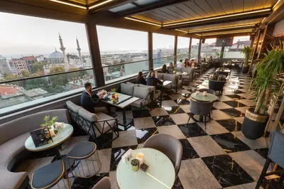 a restaurant with tables and chairs and a large window at Grand Washington Hotel in Istanbul
