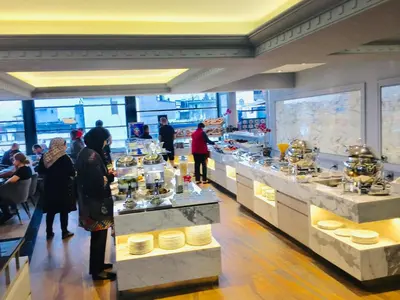 a group of people standing in a kitchen with food at Grand Washington Hotel in Istanbul