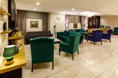 a living room with green chairs and a dining room at Golden Crown Hotel in Istanbul