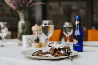 a plate of food on a table with wine glasses at Misgibi Hotel in Bursa
