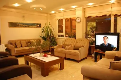 a living room with couches and a flat screen tv at Topkapı Otel Özyavuz in Istanbul