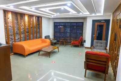 a living room with an orange couch and chairs at Long Stay İstanbul Hotel in Istanbul
