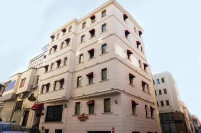 a tall white building with red bows on it at Long Stay İstanbul Hotel in Istanbul