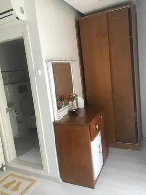 a bathroom with a wooden cabinet and a mirror at Beyhan Hotel in Istanbul