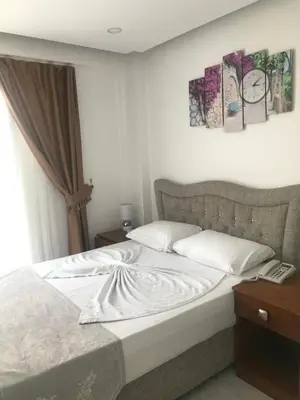 a bedroom with a large bed with white sheets at Beyhan Hotel in Istanbul