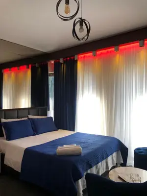 a bedroom with a bed with blue sheets and curtains at My Palace Aırport in Istanbul