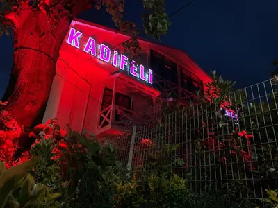a red building with a neon sign on it at Kadifeli Konak Hotel & Bungalow in Kocaeli
