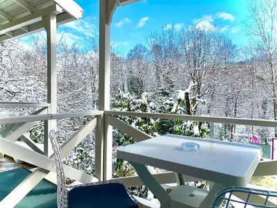 a table and chairs on a porch with snow covered trees at Kadifeli Konak Hotel & Bungalow in Kocaeli