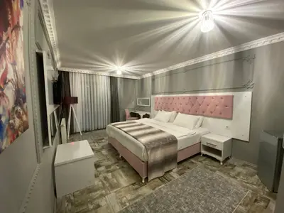 a bedroom with a large bed with a pink headboard at Kadifeli Konak Hotel & Bungalow in Kocaeli