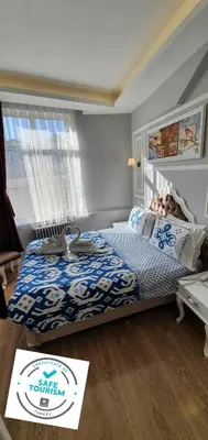 a bedroom with a bed with a blue and white comforter at Şehir Hotel Old City in Istanbul