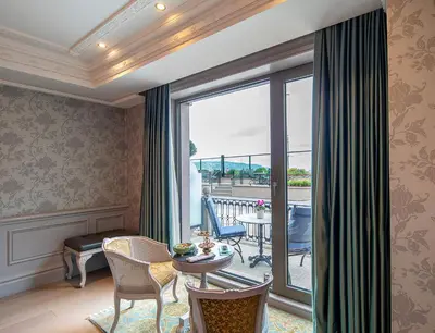 a room with a balcony with a table and chairs at MFB Tarabya Hotel in Istanbul