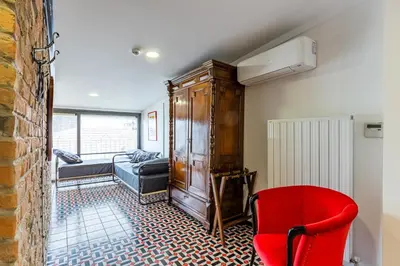 a living room with a red chair and a cabinet at Villa Pera Suite Hotel in Istanbul