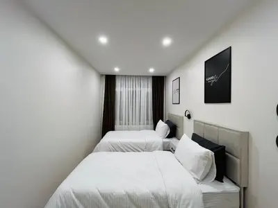 two beds in a room with white walls at Westley Residence Taksim in Istanbul