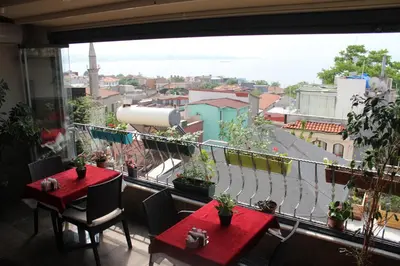 a balcony with two tables and a view of a city at Stanpoli Hostel in Istanbul