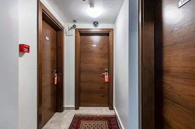 a hallway with two wooden doors and a rug at Stanpoli Hostel in Istanbul
