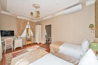 a hotel room with two beds and a living room at Enderun Hotel Istanbul in Istanbul
