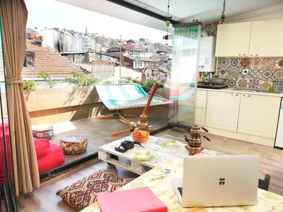 a kitchen and living room with a laptop on a table at Elele Aparts in Istanbul