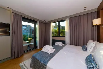 a bedroom with a large white bed and large windows at Opale Hotel in Istanbul