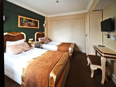 a hotel room with two beds and a desk at Elysion Hotel in Istanbul