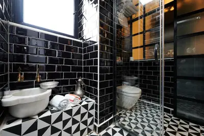 a black tiled bathroom with a sink and a toilet at Faik Pasha Hotels Special Category Beyoglu Istanbul in Istanbul