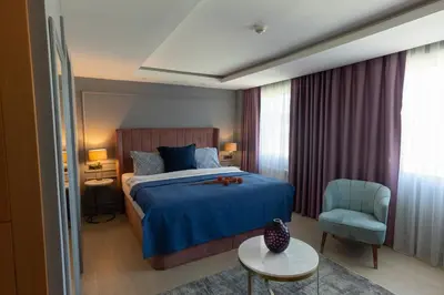 a bedroom with a blue bed and a chair at Malta Bosphorus Hotel in Istanbul