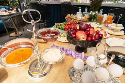 a table with a bowl of fruit and a bowl of eggs at Malta Bosphorus Hotel in Istanbul