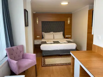 a bedroom with a bed and a purple chair at Spinel Hotel - Old City in Istanbul
