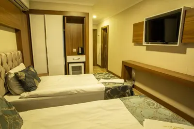 a hotel room with two beds and a flat screen tv at Bursa Palas Hotel in Bursa