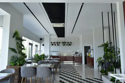 a dining room with tables and chairs and plants at Green Hills Suites in Yalova