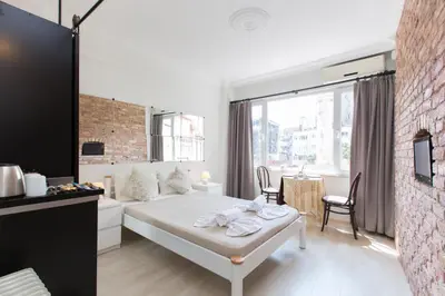 a bedroom with a white bed and a brick wall at Antique Boutique in Istanbul