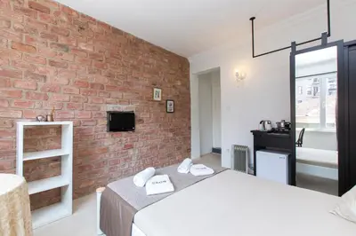 a bedroom with two beds and a brick wall at Antique Boutique in Istanbul