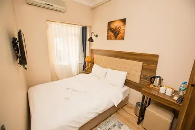 a small bedroom with a bed and a desk at Corner Garden Hotel in Istanbul