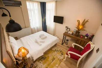a bedroom with a bed and a table and a chair at Corner Garden Hotel in Istanbul