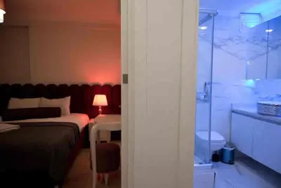 a bedroom with a bed and a glass shower at Nupelda Residence Hotel in Istanbul