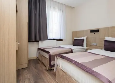 a hotel room with two beds and a window at Princess Residence in Istanbul