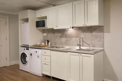 a kitchen with white cabinets and a washer and dryer at Meroddi La Porta in Istanbul