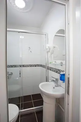 a white bathroom with a sink and a shower at Sofia Corner Hotel in Istanbul