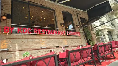 a restaurant with red chairs in front of a building at Safir Gold Hotel in Istanbul