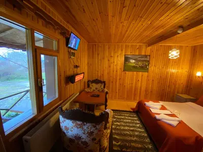 a bedroom with a bed and a table and a window at Ağva Green River Hotel in Agva