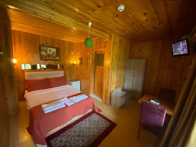 a bedroom with a bed in a wooden room at Ağva Green River Hotel in Agva