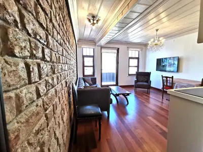 a living room with a stone wall and chairs at Ottobalat in Istanbul