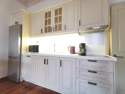 a kitchen with white cabinets and a refrigerator at Ottobalat in Istanbul