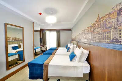 a hotel room with two beds and a painting on the wall at The Tango Hotel Taksim in Istanbul