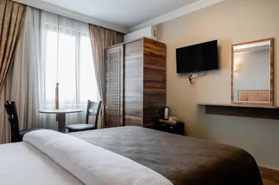 a hotel room with a bed and a television and a table at madame roza in Istanbul